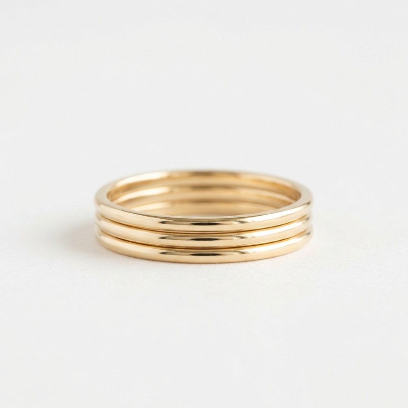 A minimal product image of a thin gold band ring with a simple elegant design on a clean white background