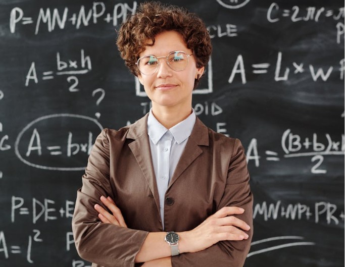 Female teacher standing in front of the blackboard