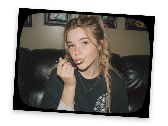 A photo with a black frame featuring a girl holding a spoon