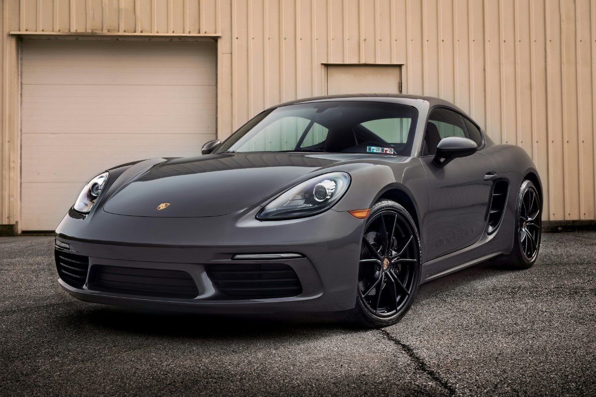 A black luxury car in front of a garage