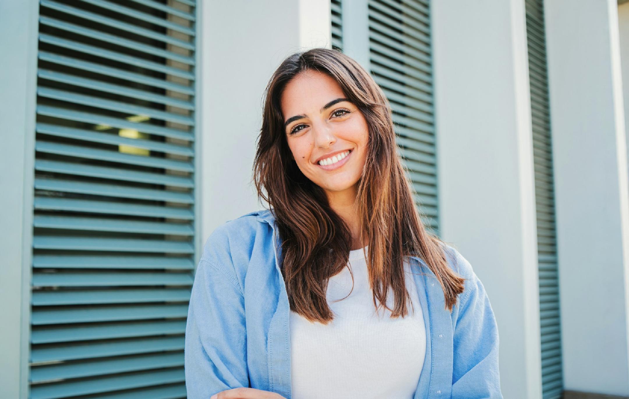 A woman in yellow shirt smiling at the camera