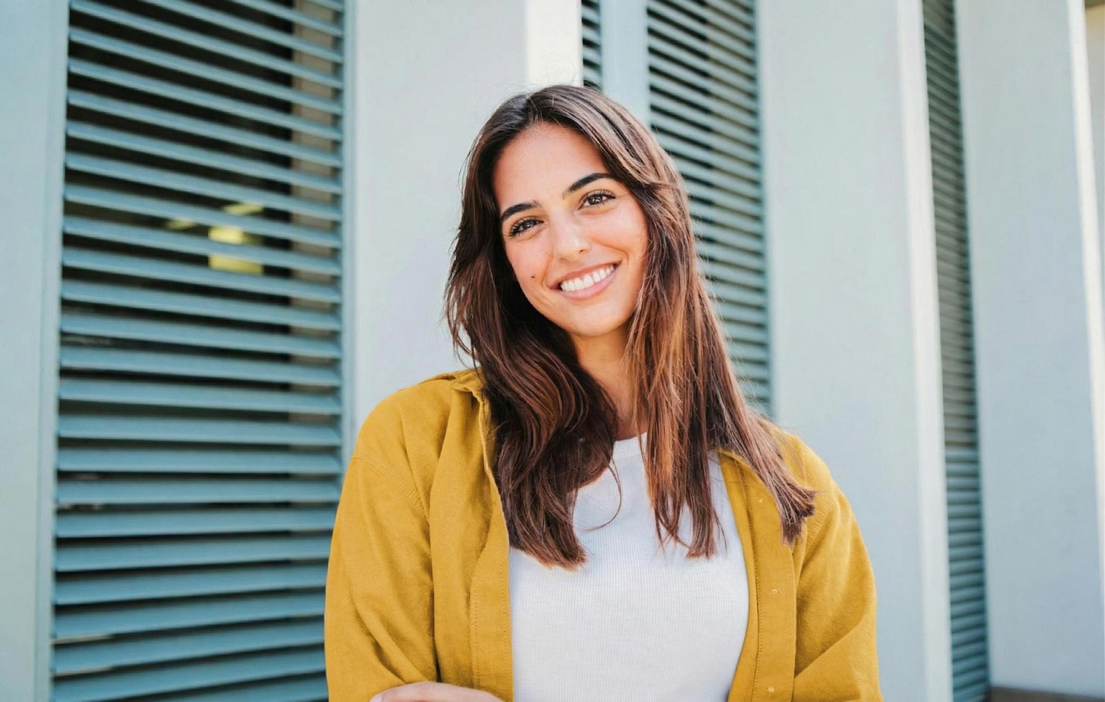 A woman in yellow shirt smiling at the camera