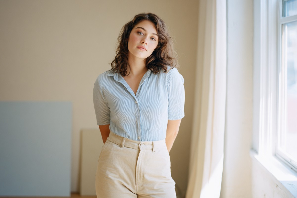 An original photo of a beautiful woman standing by the window